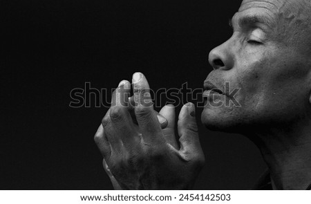 praying to god with hands together on dark background with people stock photo