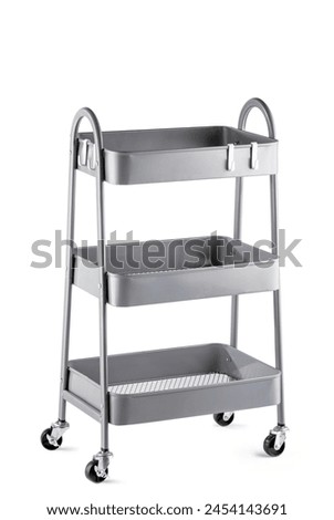 Functional gray metal cart with three tiers of large baskets, convenient handles and swivel wheels, designed for easy transportation and storage of items, ideal for organizing home and office space Royalty-Free Stock Photo #2454143691