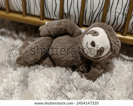 sloth plush stuffed animal relaxing by crib