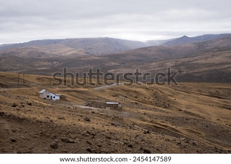 Mountain scenery on a cloudy day with a small house and a corral in northern Neuquén province, Patagonia Argentina. Space for text.