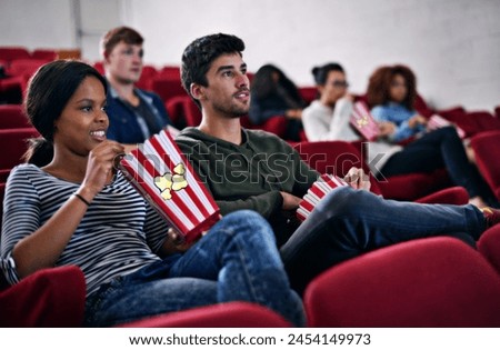 Movie, date and couple in cinema at night with popcorn to relax and watch in theatre with happiness. Film, experience and people in audience enjoy funny comedy, drama performance or eating snack food