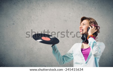 Young woman in casual wearing headphones and holding disco plate