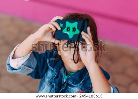 
girl takes pictures with a toy camera