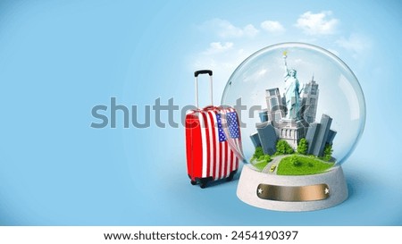 American travel icons: suitcase and Statue of Liberty snow globe.
This royalty-free stock photo features a closed, red hard-shell suitcase with a blue and white American flag design on the front.