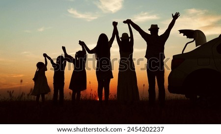 Happy family, silhouettes at sunset. Big family kids childs siblings parents holding hands appreciating enjoying orange setting sun together by car. Closeness family bonds joint recreation at nature