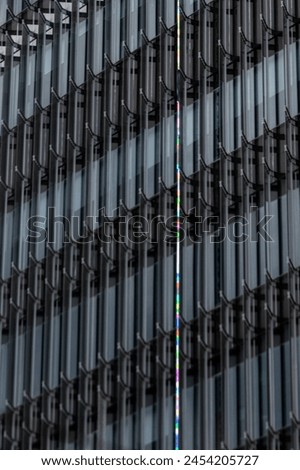 Experience the grandeur of modern architecture with this stunning image showcasing the facade of a large building adorned with numerous glass windows, reflecting the brilliance of natural light 