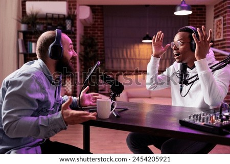 Interesting guest on online podcast show telling unbelievable story to host, shocking him and viewers watching during live broadcast. Presenter using audio recording technology in home studio