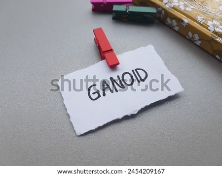 Ganoid writting on table background.