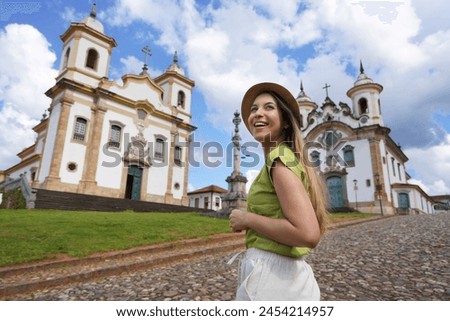 Tourism in Mariana, Minas Gerais, Brazil. Traveler girl visiting the historical town of Mariana with baroque colonial architecture. Mariana is the oldest city in the state of Minas Gerais, Brazil. Royalty-Free Stock Photo #2454214957