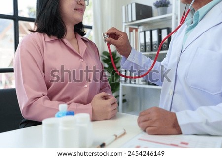 An elderly medical professional uses a stethoscope to listen to a patient's heartbeat and pulse. Before planning treatment, medicines, service concepts health care health insurance.