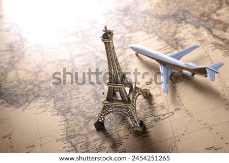 An image of traveling abroad using a world map, airplane, and model of the Eiffel Tower