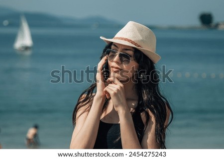young woman on the beach talking on the smartphone