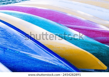 Colorful kayaks lined up closely together Royalty-Free Stock Photo #2454282891
