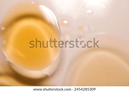 Photograph of mixed yellow oil spheres floating on the surface of the water.