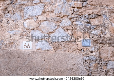 Wall of an old house with the inscription of the year 1767, in addition to the numbers 66 and 68, in a village in Catalonia (SPAIN) Royalty-Free Stock Photo #2454300693