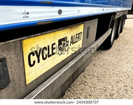 The 'cyclist alert' sign on the side of  a cmmercial vehicle trailer, part of a 44-tonne rig.  