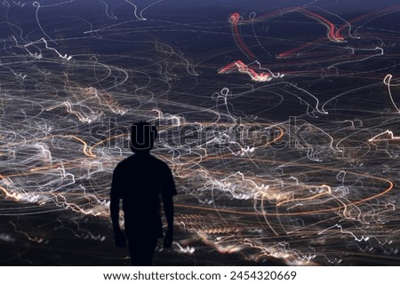A silhouette image of a boy standing in front of low shuttle lightings 
Picture of a boy standing on the view point of a hills