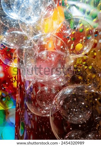 A large number of transparent plastic bubbles floating in the air. The balls are in a colorful red-yellow room, creating a visually attractive and playful atmosphere Royalty-Free Stock Photo #2454320989