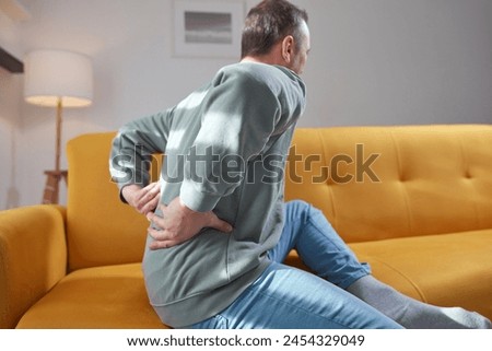 Man with hip, back and sciatica pain at home.