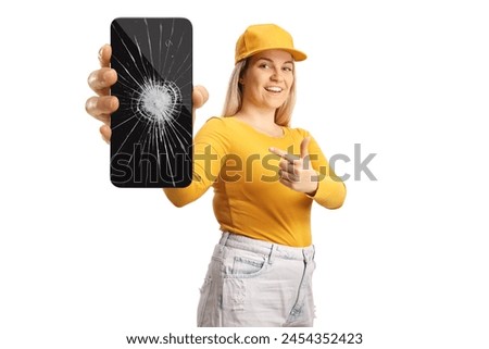 Young female pointing at a smartphone with broken screen glass isolated on white background