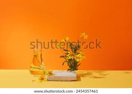 Front view of empty brick podium and fresh calendula flower on orange background. Minimal background with copy space for cosmetics, business branding and product presentation. Space for text