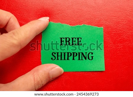 Free shipping words written on ripped green paper with red background. Conceptual free shipping symbol. Copy space.