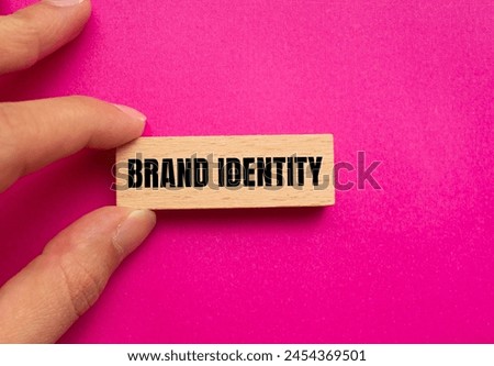 Brand identity words written on wooden blocks with pink background. Conceptual brand identity symbol. Copy space.
