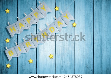 Happy birthday greeting text hanging on the rope with wooden background. Happy birthday concept