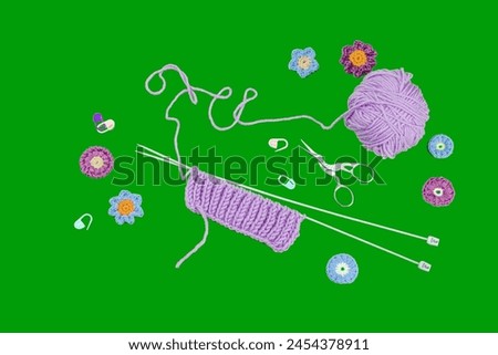 Spring knitting concept. Pattern example, traditional tools, ball of yarn, crocheted flowers. Creative handmade flat lay, bright green background, top view Royalty-Free Stock Photo #2454378911