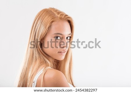 Young woman with blonde hair glances sideways, expression mingled with curiosity and pensiveness