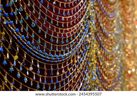 Golden jewelry necklaces decorated with semiprecious stones showing at traditional middle eastern bazaar Royalty-Free Stock Photo #2454395507