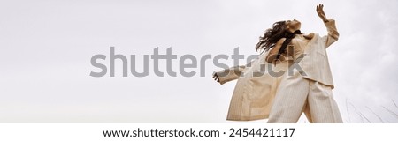 A young woman in a white outfit gracefully flying through the air, enjoying the summer breeze in a natural setting.