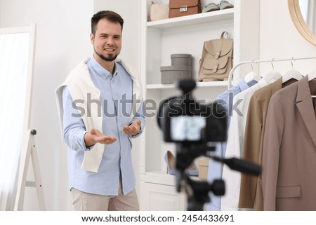 Smiling fashion blogger explaining something while recording video at home Royalty-Free Stock Photo #2454433691