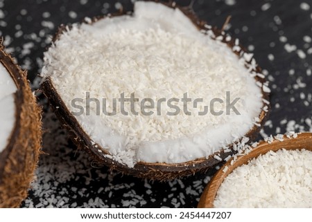 white coconut pulp and dried coconut flakes, a close-up of which is used in the preparation of desserts Royalty-Free Stock Photo #2454447207