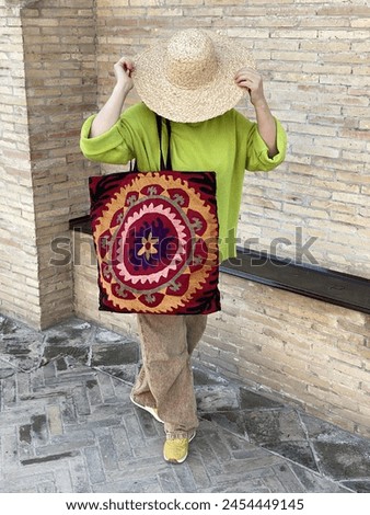 A girl in a bright green sweater and a shopper with embroidery