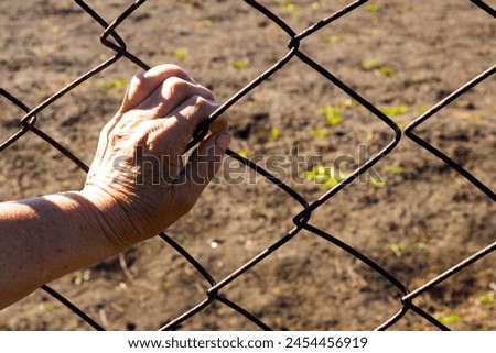 Hand on metal fence close up photo