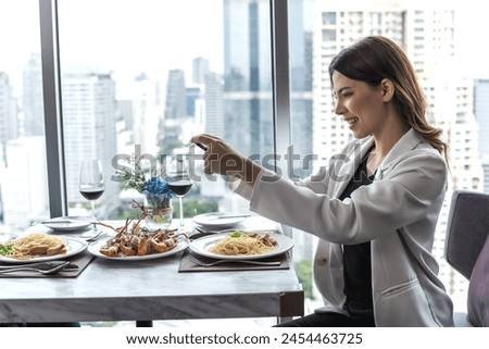 Young Asian woman using smartphone taking photo from seafood dinner on table 