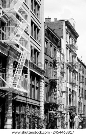 New York City, United States - old residential buildings in Soho district. Fire escape stairs. Black and white retro filter photo.