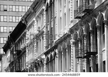 New York City, United States - old residential buildings in Soho district. Fire escape stairs. Black and white retro filter photo.