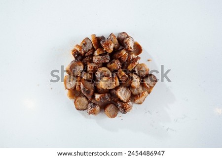 A top down view of a pile of sliced sausage links, against a white background.