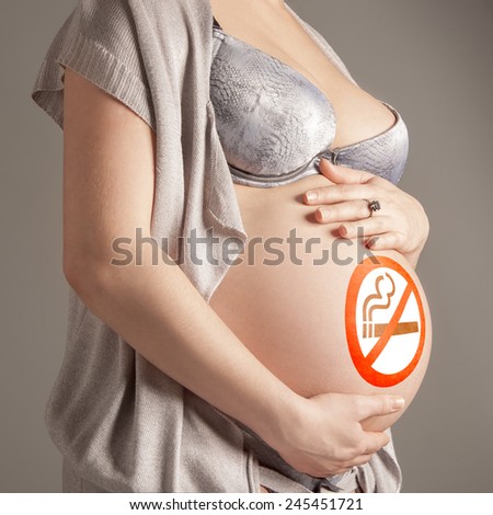Pregnant woman with sign No smoking on her belly