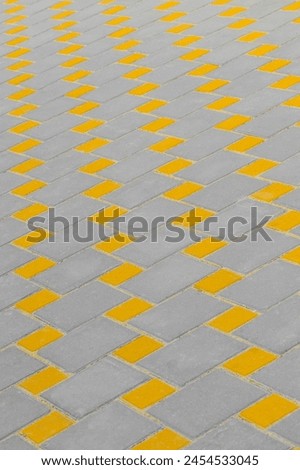 Yellow and grey paving slabs floor abstract pattern city street surface stone texture background tile.