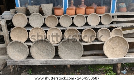 Mortar and Pestles Arranged in a Row on Wooden Rack. A set of mortar and pestles, traditional tools used for grinding ingredients, arranged in a row on a wooden rack. Royalty-Free Stock Photo #2454538687