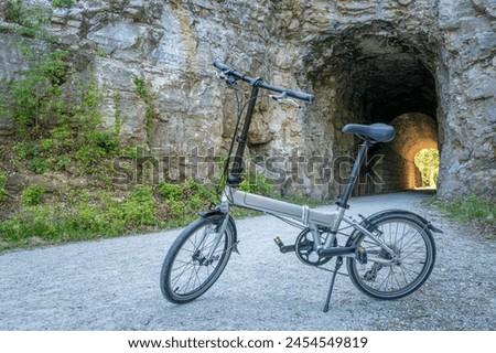 Folding bike on Katy Trail at a tunnel near Rocheport, Missouri, spring scenery. The Katy Trail is 237 mile bike trail converted from an old railroad. Royalty-Free Stock Photo #2454549819