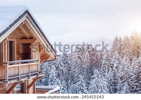 Snow covered chalet in the mountains Royalty-Free Stock Photo #245455543
