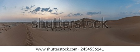 A panorama picture of the desert landscape outside of Abu Dhabi at sunset.