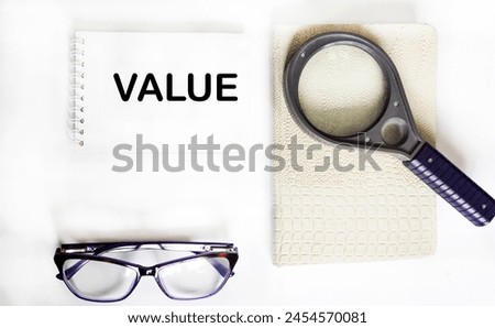 Notepad with word VALUE on white background with copy space. Business concept image.