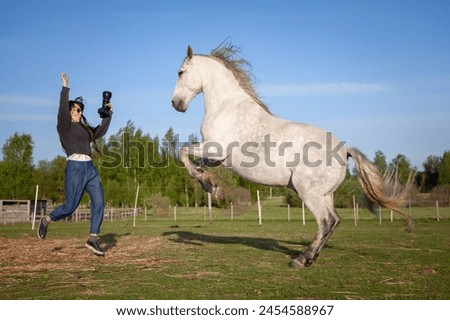 Beautiful young woman making pictures of horse