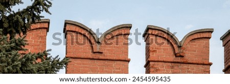 View of a fragment of the battlements of the fortress wall. Battlements of the upper part of the Kremlin fortress wall. Russia, Kremlin Royalty-Free Stock Photo #2454595435