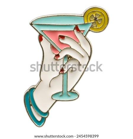 Metal pin in the form of a woman's hand holding a margarita cocktail. Stylish fashion accessory.